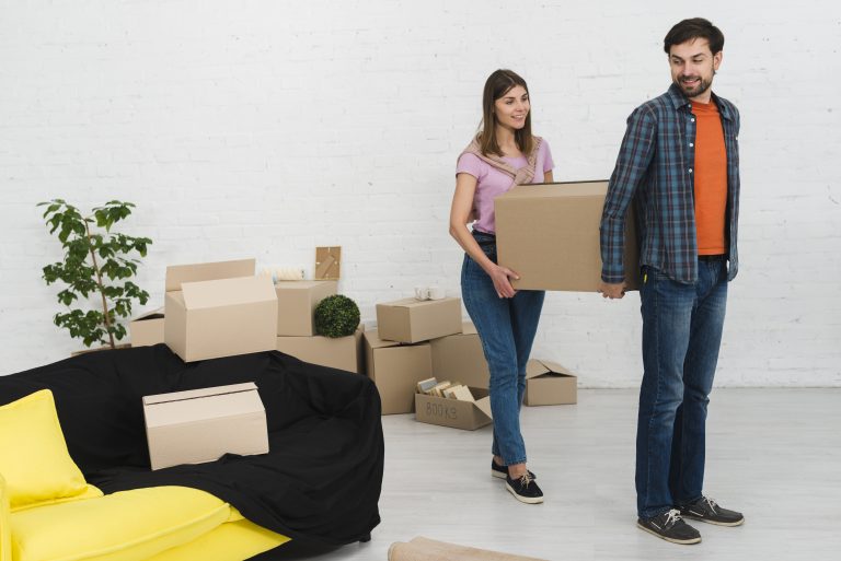 young-couple-holding-cardboard-box-their-new-house
